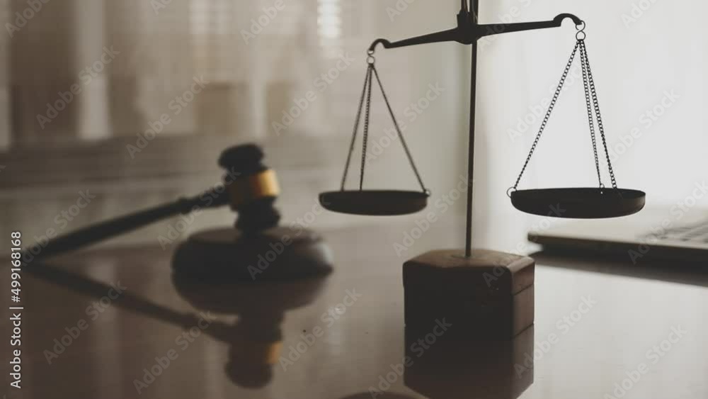 Business and lawyers discussing contract papers with brass scale on desk in office. Law, legal services, advice, justice and law concept picture with film grain effect