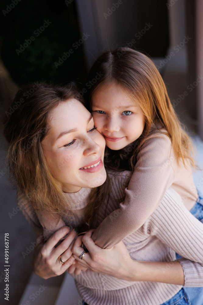 Lovely family mother and daughter embracing and kissing each other