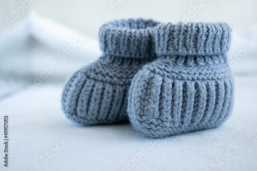 Blue knitted socks for newborn babies. Close up. Concept of handmade knitted clothes for babies.
