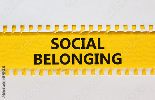 Social belonging symbol. Yellow and white paper with concept words Social belonging on beautiful white background. Business political social belonging concept. Copy space. photo