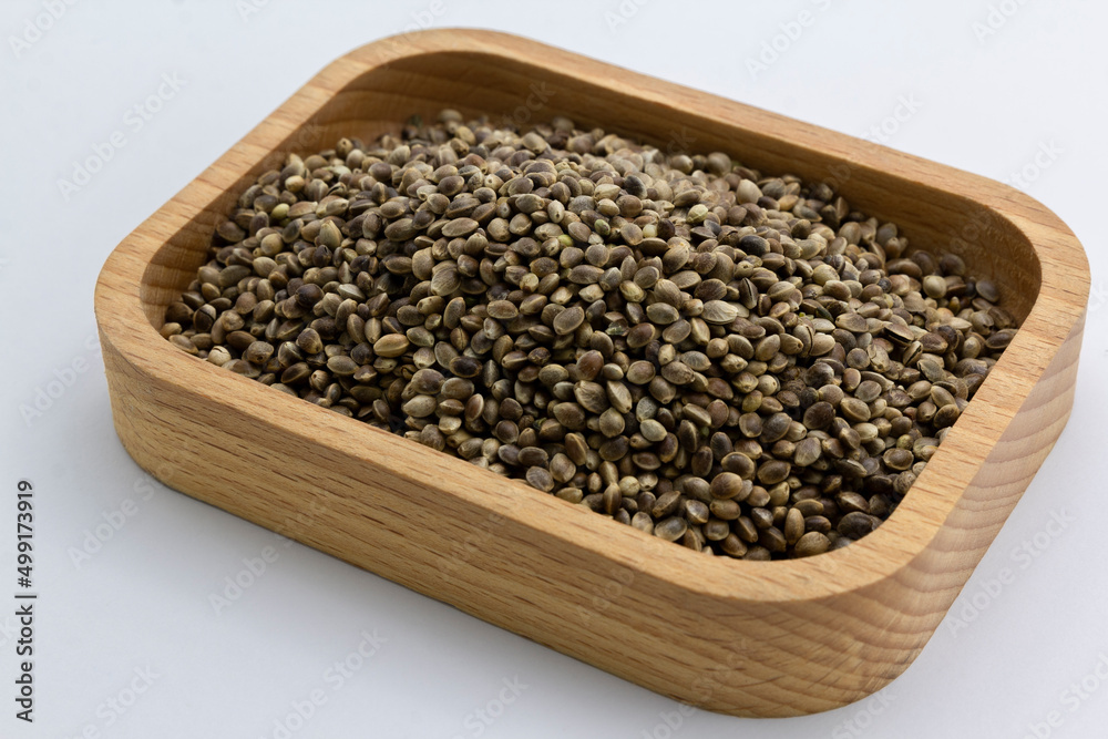 cannabis seeds on a wooden plate on white background, copy space top view horizontal. Banner, cover, mockup, for your design