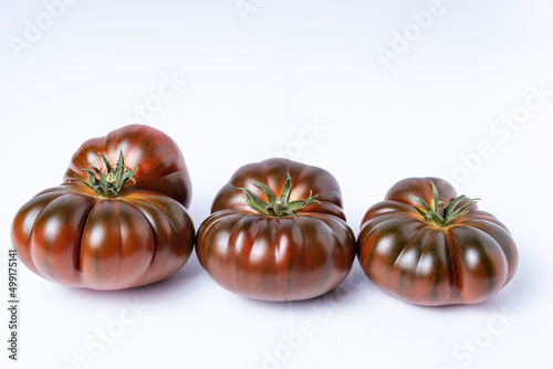 Fotografia Black raf tomato,three tomatoes with different shapes on white background
