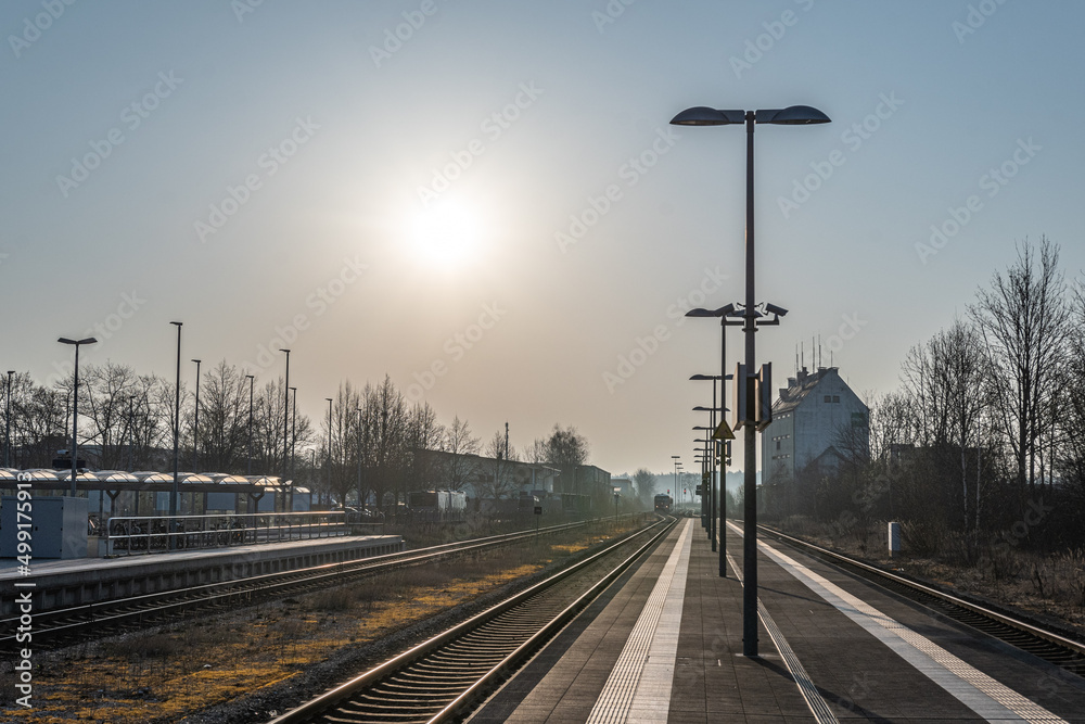Fototapeta premium Bahnhof mit Gleisen im Gegenlicht am morgen