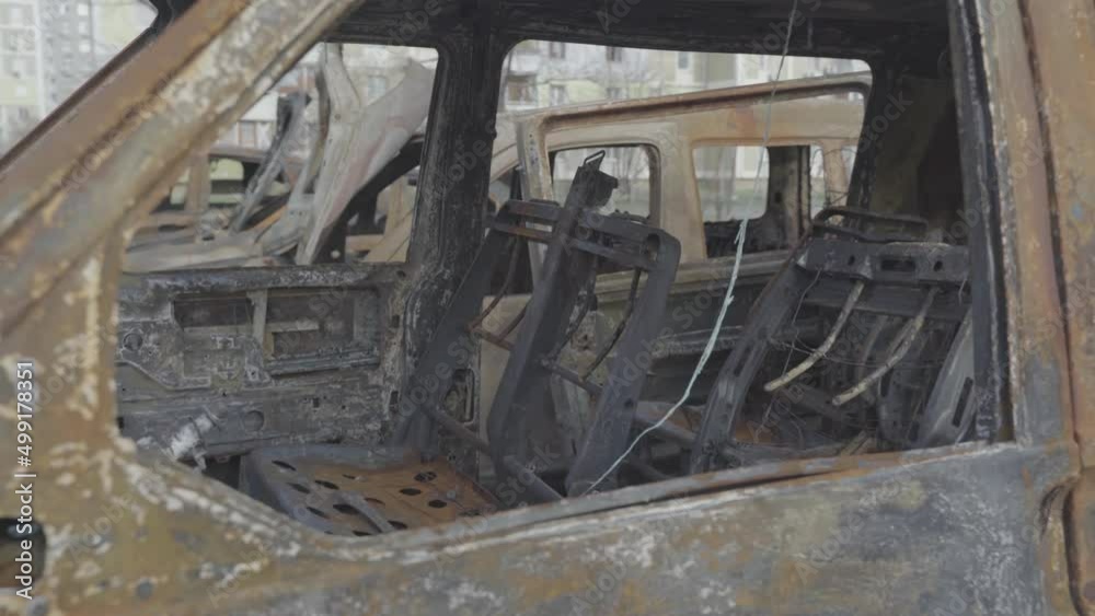 Burnt cars in a parking lot near residential buildings after the city was bombed. Ukraine. Kyiv. District Troieshchyna Burnt cars in a parking lot near residential buildings after the city was bombed. Ukraine. Kyiv. District Troieshchyna