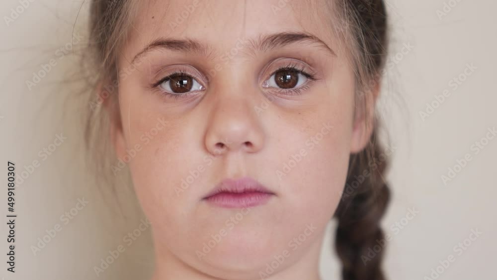 portrait child girl looking at the camera. happy family kid dream concept. baby eyes down then look at the camera and smiles. indoors funny portrait girl kid close-up. smile teeth fell out portrait child girl looking at the camera. happy family kid dream concept. baby eyes down then look at the camera and smiles. indoors funny portrait girl kid close-up. smile teeth fell out