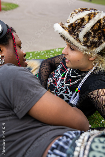 An interracial gay couple relaxing in the park.