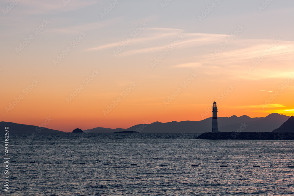 Seascape at sunshine. Lighthouse and sailings on the coast. Turgutreis Lighthouse at Sunset. Sea breeze and salty fresh smell.