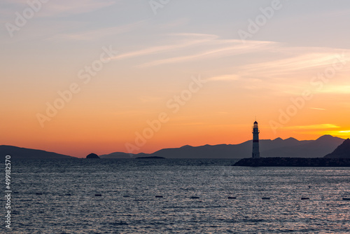 Seascape at sunshine. Lighthouse and sailings on the coast. Turgutreis Lighthouse at Sunset. Sea breeze and salty fresh smell.