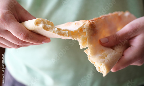 Flour bun flatbread in hands break apart