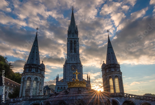 The sun star among the bell towers of the pilgrimage basilica of the apparitions of Mary in Lourdes