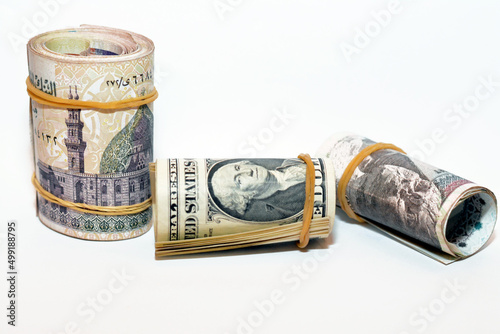 Selective focus of a pile of American dollars rolls with rolled up Egyptian money banknote bills of 100 LE, 200 LE one hundred and two hundred pounds, USA dollar and Egyptian pound exchange rate photo