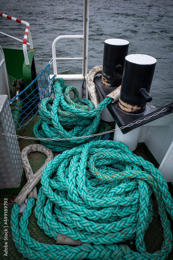 on the deck of a ship lie long ropes for mooring the ship