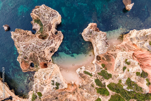 Aerial view of Praia dos Pinheiros, a beautiful paradise beach along the coast with scenic cliffs near Ponta da Piedade, Lagos, Algarve region, Portugal.