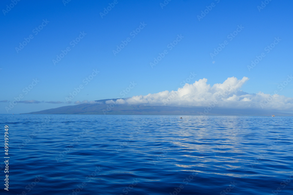 Lanai island in the Hawaiian archipelago on a sunny winter day with clouds attached to its mountains