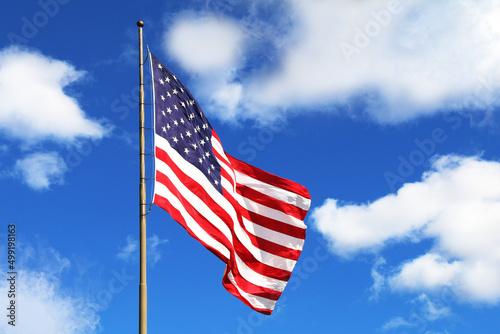 huge large waving american flag flagpole blue sky america holiday raised flying windy pride symbol red white blue clear wind tall stars stripes