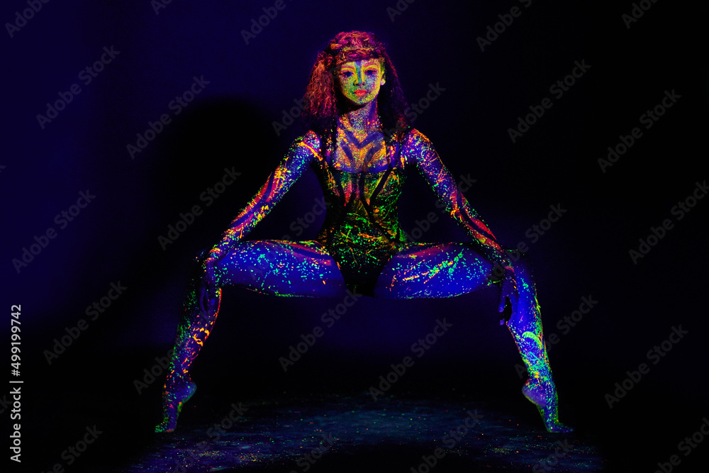 Let your imagination come to life. Full length portrait of a young woman posing with neon paint on her face.