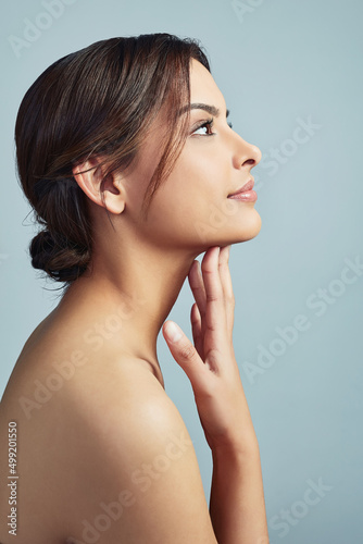 Give a girl the right skincare and shell rule. Sideview of a young woman with flawless skin against a grey background.