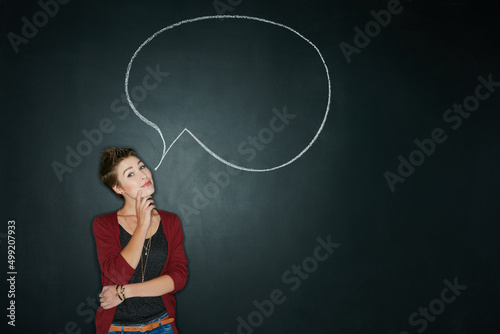 Whats your truth. Studio shot of a young woman posing with a chalk illustration of a speech bubble against a dark background.