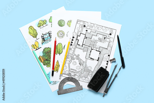 Paper sheets with sketches for landscape design and stationery on color background