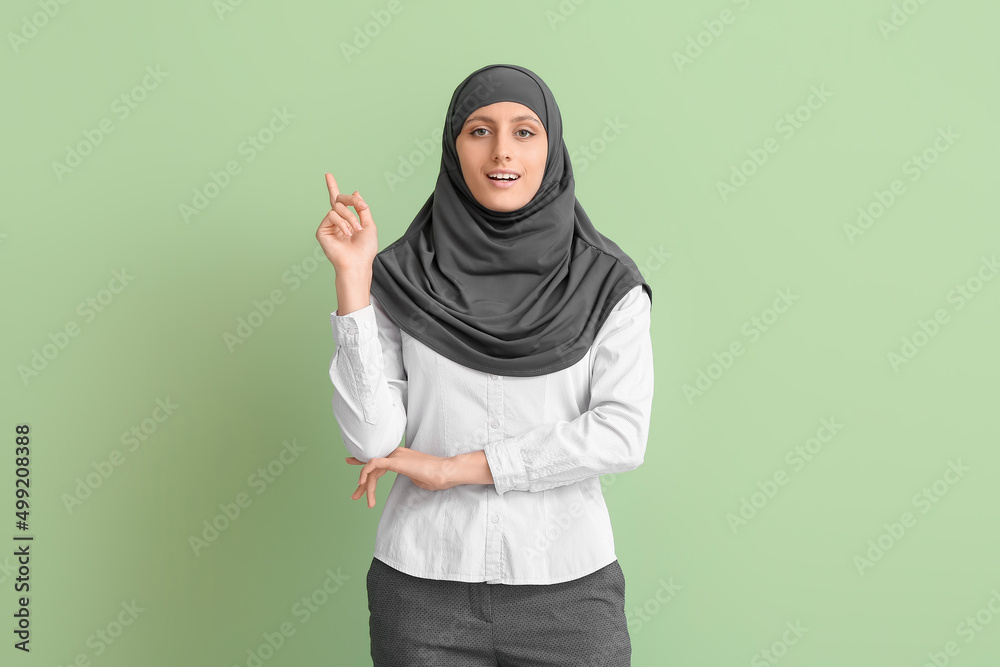 Muslim secretary pointing at something on color background Muslim secretary pointing at something on color background
