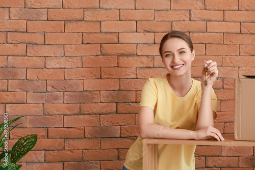 Happy young woman with key ...