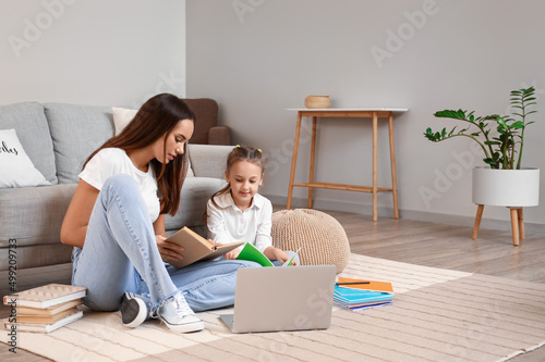 Cute girl studying with tutor at home