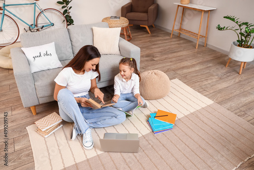 Cute girl studying with tutor at home