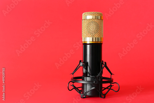 Stand with modern microphone on red background