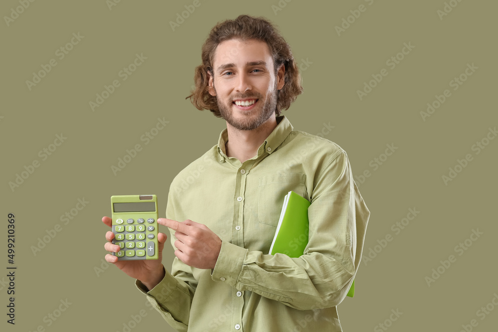 Handsome man with calculator and notebooks on green background - obrazy, fototapety, plakaty 