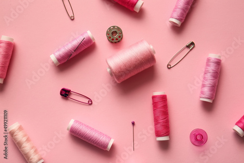 Composition with thread spools on color background