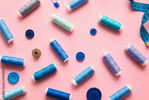 Different thread spools and buttons on color background