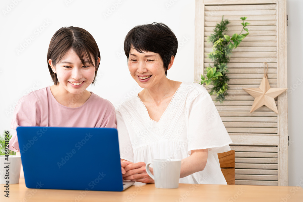 ノートパソコンを使う母と娘