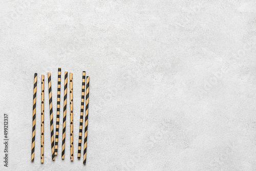 Stylish straws for drinks on grunge background