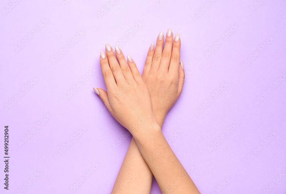 Crossed female hands with beautiful manicure on color background, closeup Crossed female hands with beautiful manicure on color background, closeup
