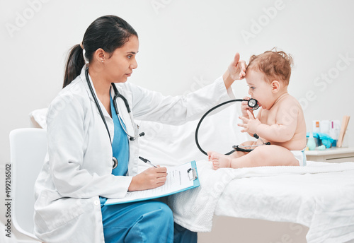 Its normal for babies to have a fever when teething. Shot of a paediatrician completing paperwork during a checkup.