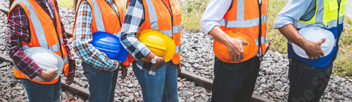 Team railway engineer holding helmet standing in row on site work, Panorama image for banner cover design.