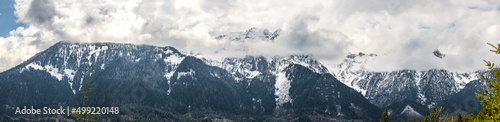 A panorama of clouds obscuring snow capped mountains in the Cascade Mountain range