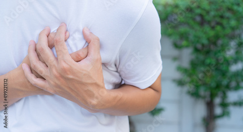 Картината върху платно close up man feeling suffering and using hand for touching on chest for checking