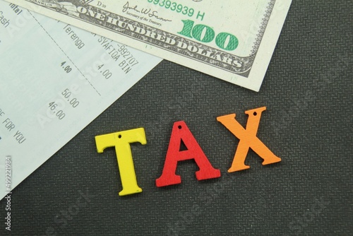 banknotes and receipts with the word tax. tax concept photo