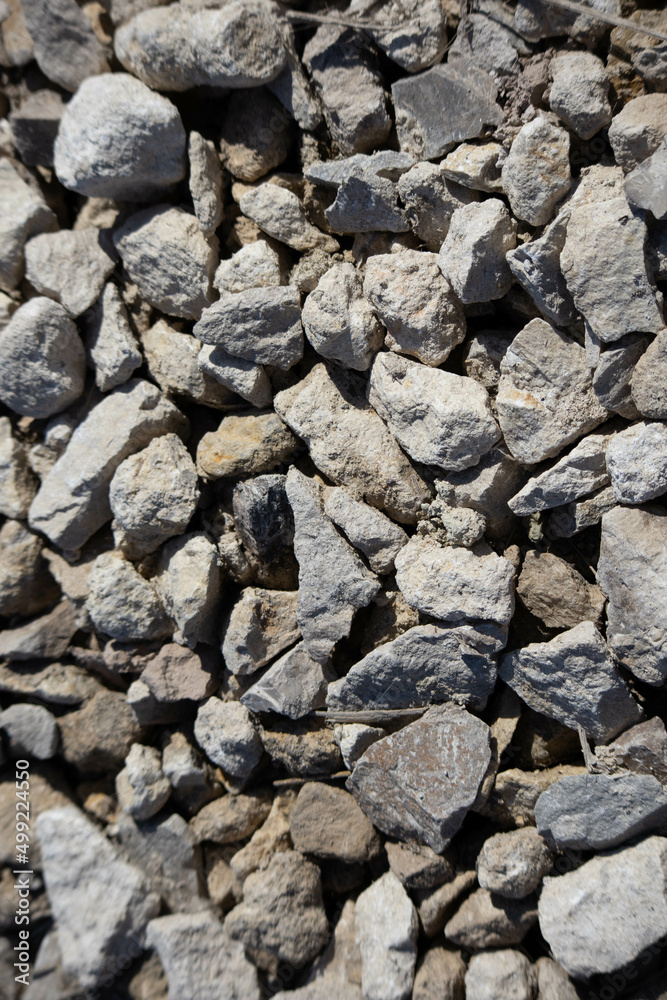Crushed stone road building material gravel texture. Small stone construction material rock.  Crushed rock close up. High quality vertical photo