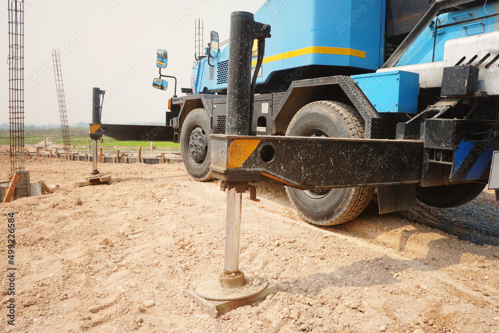 hydraulics support of blue Rough Terrain Crane is on the ground at the construction site. hydraulics support of blue Rough Terrain Crane is on the ground at the construction site.