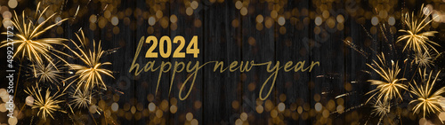 HAPPY NEW YEAR 2024 - Festive New Year's Eve firework background panorama greeting card  banner long - Golden fireworks on dark wood wall texture