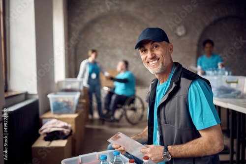 Mature man volunteering at charitable foundation and looking at camera. photo