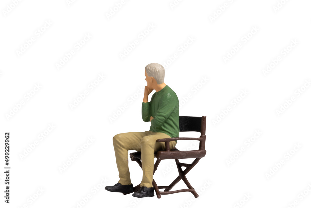 Miniature people sitting on chair isolated on white background with clipping path Miniature people sitting on chair isolated on white background with clipping path