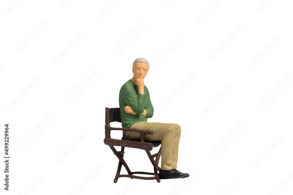Miniature people sitting on chair isolated on white background with clipping path Miniature people sitting on chair isolated on white background with clipping path