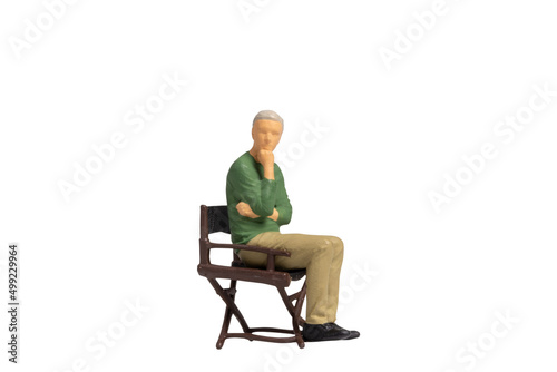 Miniature people sitting on chair isolated on white background with clipping path