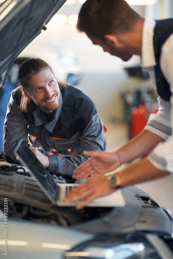 Two workers doing diagnostic on a car Two workers doing diagnostic on a car
