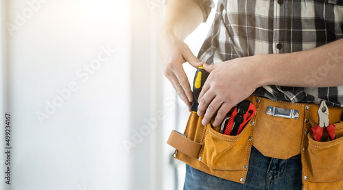 Worker assembler with tool belt full of instruments, copy space