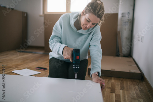 Woman assembling furniture at home 