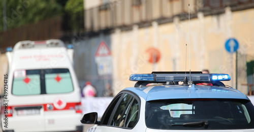 police car with blue flashing lights on it while escorting an ambulance to go to the hospital photo